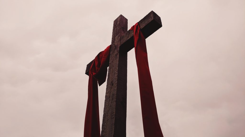 low angle view of cross with red garment