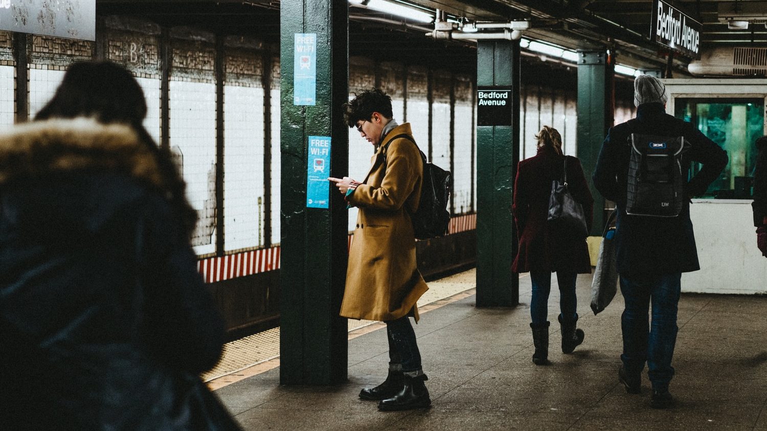 man using smartphone inside the train station