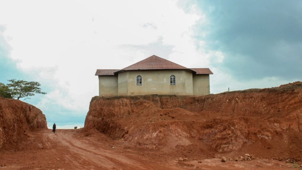 white and brown house on brown sand under white clouds during daytime