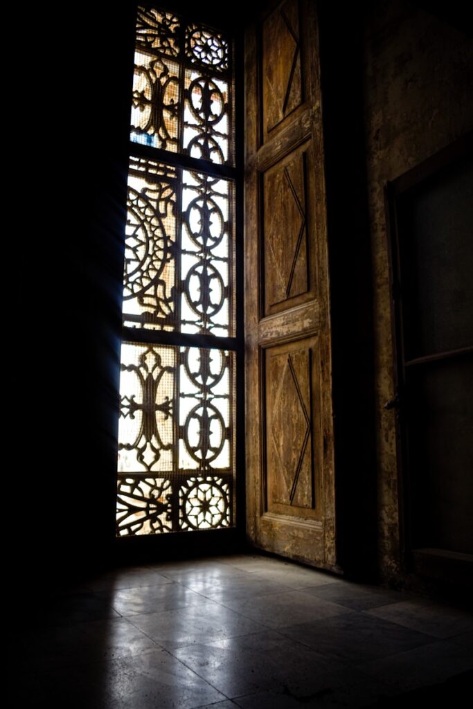 a window with a wooden frame in a dark room