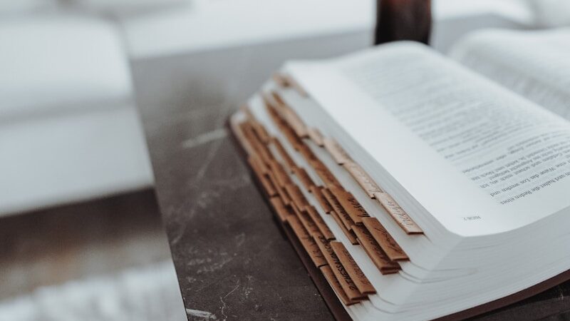 opened book on brown wooden table