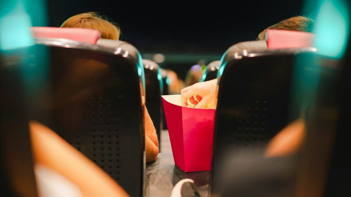 a person sitting in a chair with a red bag of food