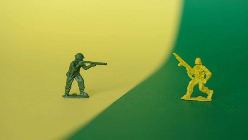 a toy soldier holding a gun next to a toy soldier