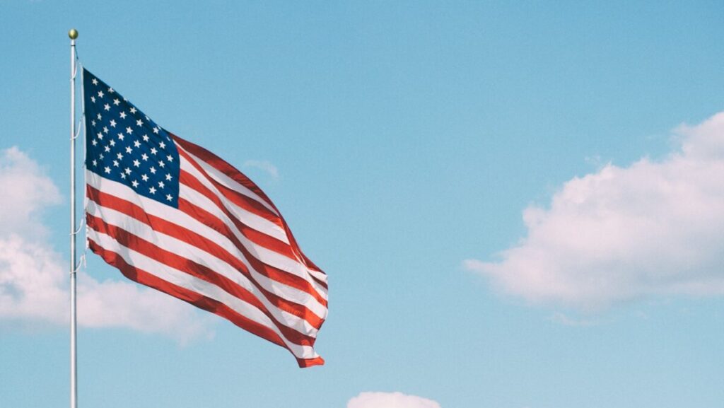 flag of U.S.A. under white clouds during daytime