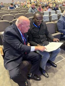 Craig Carlisle and Jarman Leatherwood are seated looking over the convention agenda items.