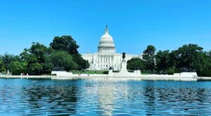 white concrete building near green trees under blue sky during daytime