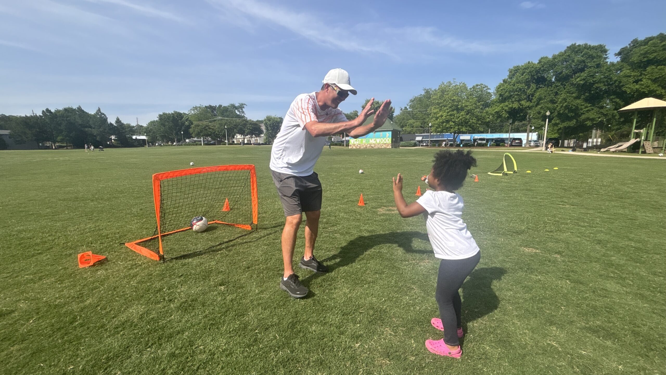 Coach cheering on young child playing soccer