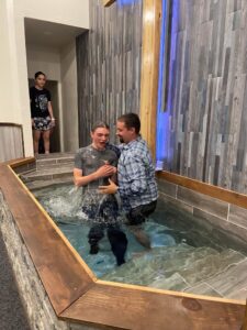 Pastor baptizing teenage son