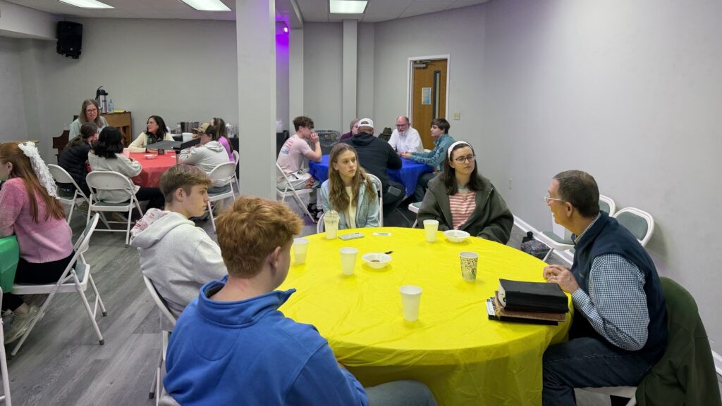 People sitting around tables similar to speed-dating concept