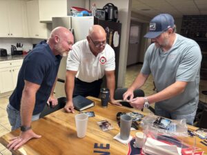 Three men looking at photos