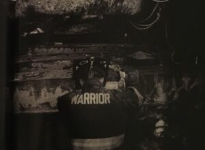 Back view of turncoat with word Warrior on nameplate